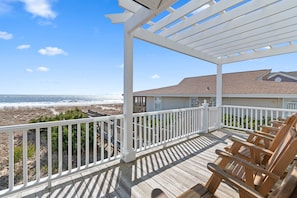 Beautiful back deck with pergola and sturdy rocking chairs.