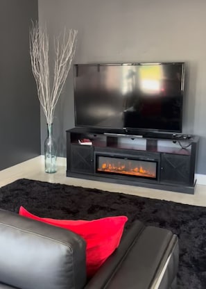 Living room with sofa, flat screen tv and fire place