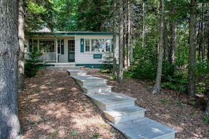 Tucked beneath a canopy of evergreens, this quiet path leads to a woodland retreat made for unwinding in nature’s rhythm.