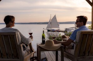 Evenings drift by in good company as the harbor glows and sailboats glide past your front-row seat to coastal calm.