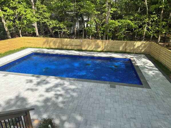 Pool from deck, newly-added stone patio