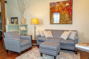 Relax in the stylish living area, beautifully accented with unique artwork that adds a touch of personality to the space.