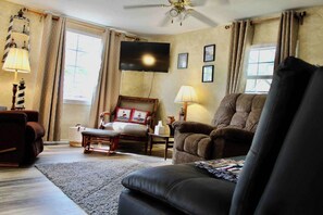 Cozy living room perfect for movie or game night with plenty of comfy seating and a mounted TV.   