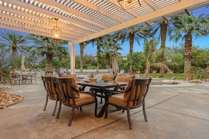 Outdoor dining area surrounded by lush palm trees, perfect for al fresco meals.