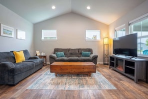 Kick back in the spacious living room, complete with comfy seating, a 70-inch smart TV, and a cozy electric fireplace – perfect for family movie nights.