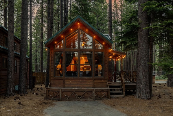 Escape to this dreamy forest cabin—cozy lights, towering pines, and peaceful vibes. Perfect for couples, small families, or anyone craving a stylish retreat in nature.