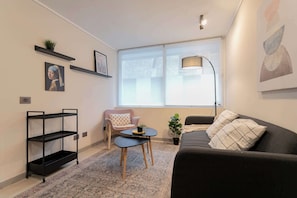 Relax in this stylish living area with modern decor and abundant natural light, perfect for unwinding after a day exploring the city.