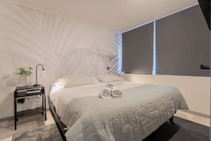 Relax in this cozy bedroom with soft lighting and elegant decor, perfect for unwinding after a day exploring the city.