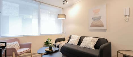 Relax in a stylish living area with modern decor, ample seating, and natural light, perfect for unwinding after exploring the city.