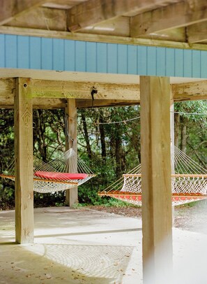 Hammocks hang under the house.