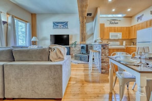 Thoughtfully placed décor, including wooden accents, ranch-themed artwork, and soft throw blankets, contribute to the warm, inviting feel of the living room.