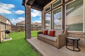 Our backyard porch with seating for 3 and an electric BBQ Grill.