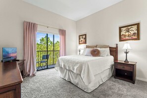 Recharge in this cozy queen bedroom, featuring balcony access