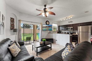 Bright living area with cozy seating, Smart TV, and patio