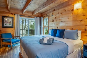 Tranquil bedroom with a king-sized bed and natural wood accents, offering a peaceful retreat. 🌙🛏️
