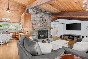 Spacious living room with fire place looking into the kitchen