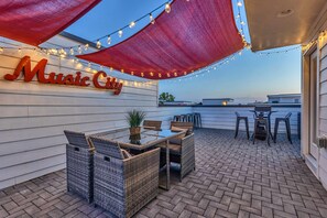 Chic rooftop deck with vibrant lights and stunning city views—perfect for gatherings like bachelorette parties or corporate retreats. Enjoy Nashville's spirit and create unforgettable memories under the stars!