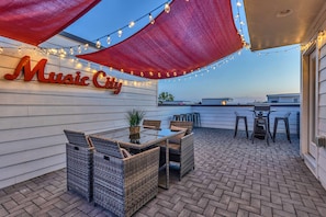 Chic rooftop deck with vibrant lights and stunning city views—perfect for gatherings like bachelorette parties or corporate retreats. Enjoy Nashville's spirit and create unforgettable memories under the stars!