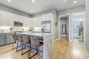 Explore this chic modern kitchen, ideal for cooking and gatherings. With elegant finishes and ample space, it's perfect for family reunions or bachelorette getaways before heading out to Downtown Nashville. Your luxury vacation rental adventure begins here!