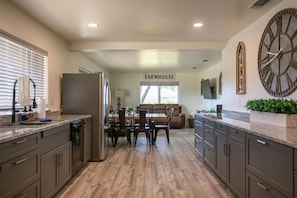 Spacious farmhouse kitchen with cozy dining and living space.