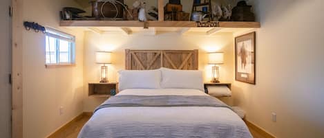 Rustic queen bed with warm lighting.
