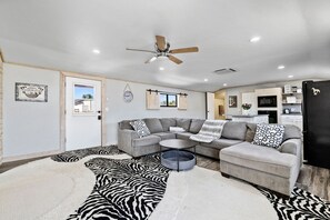 Bright and playful living space with zebra flair, cozy seating, and easy access to the kitchen and front entry.