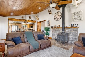 This cozy living area features rustic charm and comfort, complete with a wood-burning stove, plush seating, and warm wood accents—perfect for relaxing after a day of ranch adventures. 🪵🔥