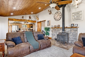 This cozy living area features rustic charm and comfort, complete with a wood-burning stove, plush seating, and warm wood accents—perfect for relaxing after a day of ranch adventures. 🪵🔥