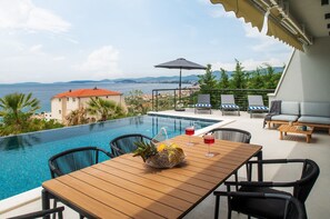 In front of the dining/living room are a covered dining area for 8 people and a very comfortable lounge corner, all with sea views.