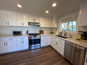kitchen with gas stove/oven and fume hood. Instant hot water dispenser