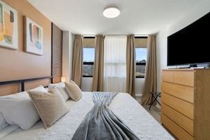 Comfortable and spacious bedroom featuring a king bed and warm design touches.