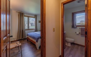 Bedroom 2 with full bed and a full bathroom with step in shower down the hall