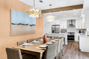 Gather around the 8-seater dining table, brightened by great lighting and a stylish chandelier—perfect for meals and memories! | White Sands, Paradise Isles, Destin | Voyax Luxury Vacation Rentals