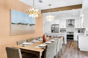 Gather around the 8-seater dining table, brightened by great lighting and a stylish chandelier—perfect for meals and memories! | White Sands, Paradise Isles, Destin | Voyax Luxury Vacation Rentals