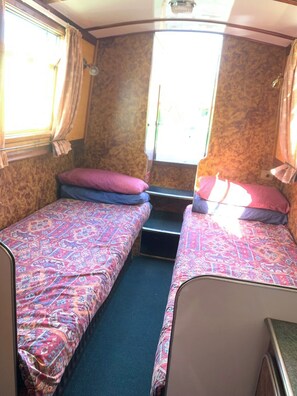 2 singles which can convert to a double bed at night. SHe has draws and wardrobes for storage.