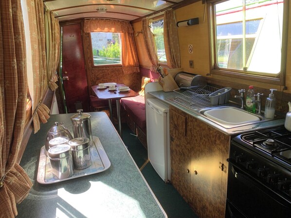 Galley with full size cooker, fridge with small freezer box.