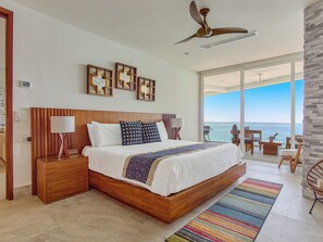 Master Bedroom — King size bed, smart TV, ensuite bathroom, and ocean views