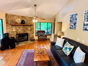 Living room with wood burning stone fireplace.