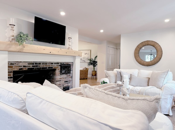 Living room with an adjoining banquette dining area and a sitting room.