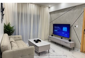 Spacious living room with smart TV, Alexa pod, and connects to the terrace.