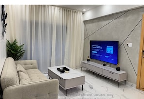 Spacious living room with smart TV, Alexa pod, and connects to the terrace.