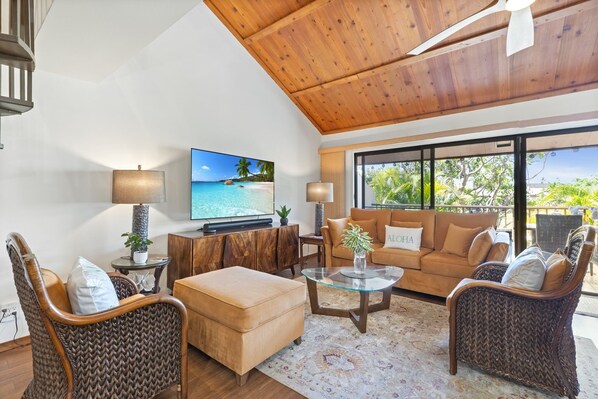 Relax in the spacious living room with comfortable seating and a large flat-screen TV.