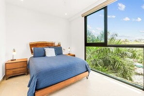 Find solace in the queen bed in the second bedroom while absorbing the captivating views of San Pancho town, and the verdant jungle mountains through the floor-to-ceiling window.