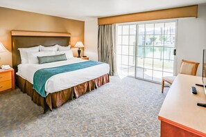 A spacious bedroom provides a restful haven with ample natural light, plush bedding, and a serene view of the outdoor landscape, ensuring a peaceful night's sleep for all guests.