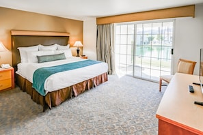 A spacious bedroom provides a restful haven with ample natural light, plush bedding, and a serene view of the outdoor landscape, ensuring a peaceful night's sleep for all guests.