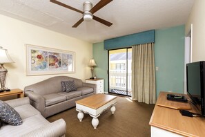 Relax in the cozy living area of this 1-bedroom condo, featuring a comfortable sofa bed and easy access to a private balcony for stunning views.
