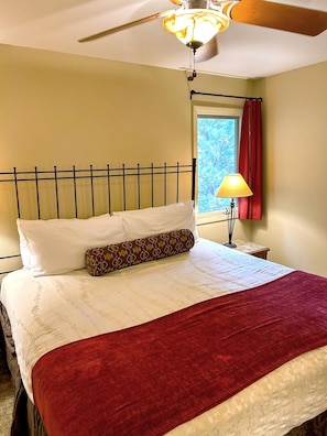 A comfortable bedroom furnished with a plush king bed and a cozy reading nook invites restful nights in a warm and tranquil setting.