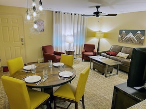 The inviting modern dining area combines style with functionality, featuring a round table set for a meal, complemented by a cozy seating area for relaxation.