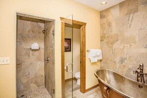 Indulge in luxury with a beautifully designed bathroom featuring a stylish freestanding tub and a spacious glass shower.
