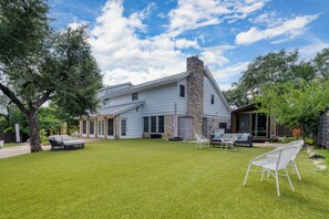 Expansive backyard lawn with a view of the rear exterior of the main house.